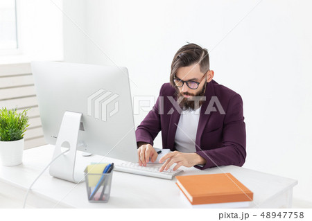 People and technology concept - Attractive man with beard working on at the computer 48947758