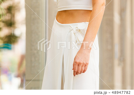 Woman wearing white trousers culottes Woman wearing white trousers culottes 48947782