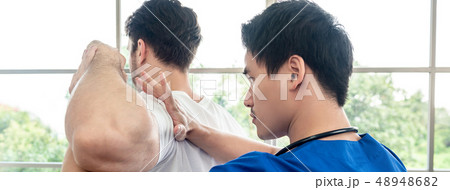Physical therapist stretching athlete male patient 48948682