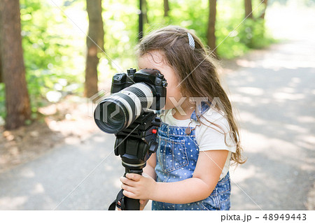 Hobby, profession, children and photographer concept - child with camera in forest 48949443