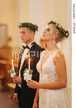 Beautiful couple in church. Newlyweds swear to each other to love forever. Happy bride and groom Beautiful couple in church. Newlyweds swear to each other to love forever. Happy bride and groom 48949794