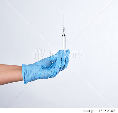 hand in a blue sterile glove holds a plastic hand in a blue sterile glove holds a plastic 48950367