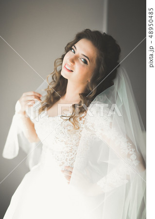 Luxury bride in white dress posing while preparing for the wedding ceremony 48950485