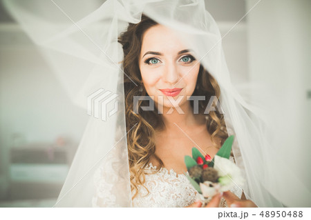 Luxury bride in white dress posing while preparing for the wedding ceremony 48950488