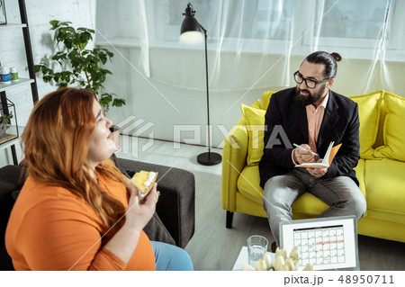 Positive delighted female person eating tasty cheesecake Positive delighted female person eating tasty cheesecake 48950711