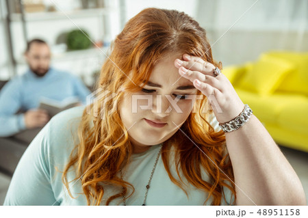 Worried red-haired woman standing on the foreground Worried red-haired woman standing on the foreground 48951158