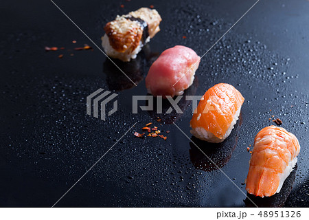 Sashimi, uramaki and nighiri, Japanese dish consisting of rice, salmon or tuna, shrimp in black with Sashimi, uramaki and nighiri, Japanese dish consisting of rice, salmon or tuna, shrimp in black with 48951326
