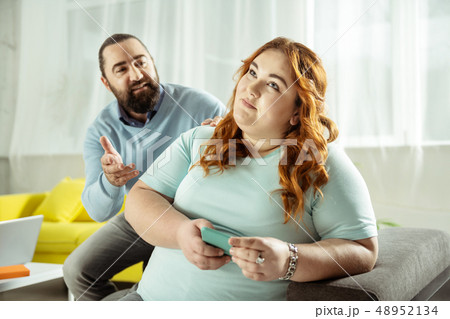 Dreamy curly-haired female listening to her interlocutor 48952134