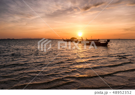 Wooden long-tail boats on tropical sea at sunrise 48952352