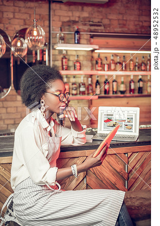 Profile shot of African-American bar employee looking at tablet 48952532