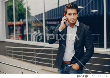 Handsome businesman in a summer city Handsome businesman in a summer city 48953925