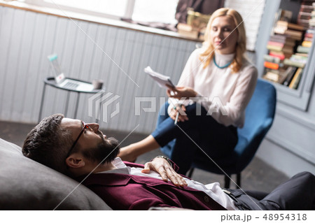 Bearded businessman lying on sofa while having psychological therapy 48954318