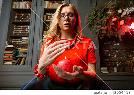 Astrologist closing eyes and breathing slowly while holding candle 48954418