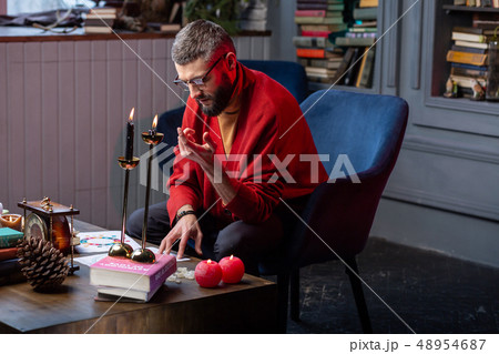 Bearded fortune-teller having some difficulties while working at home Bearded fortune-teller having some difficulties while working at home 48954687