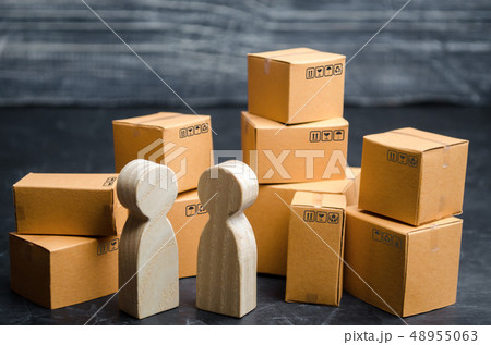 Two people discuss a business deal in a warehouse. 48955063