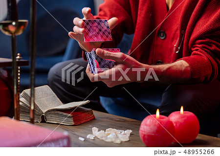 Close up of fortune-teller using oracle cards and little old book Close up of fortune-teller using oracle cards and little old book 48955266