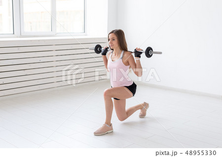 Healthy lifestyle, people and sport concept - Young and fit woman workout with lunges 48955330