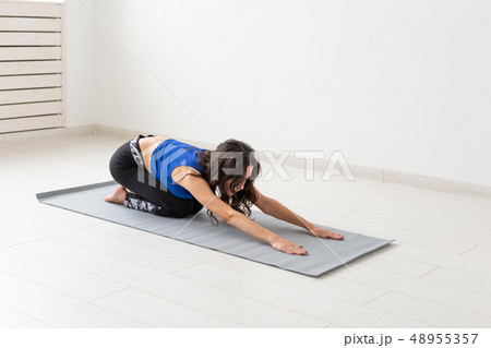 Healthy lifestyle, people and sport concept - Young woman with curly hair doing yoga over white Healthy lifestyle, people and sport concept - Young woman with curly hair doing yoga over white 48955357