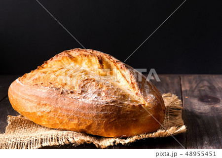 Rustic bread roll or french baguette, wheat and flour on wooden. Rural kitchen or bakery - Rustic bread roll or french baguette, wheat and flour on wooden. Rural kitchen or bakery - 48955451