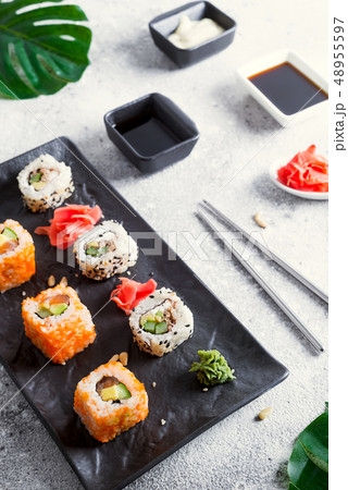 Various Fresh and delicious sushi set on black and white slate with metal and slate sticks, sauce Various Fresh and delicious sushi set on black and white slate with metal and slate sticks, sauce 48955597