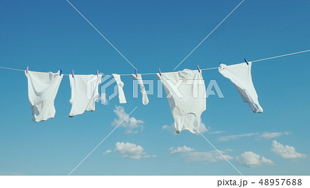 White linen dries on the rope against the blue sky 48957688