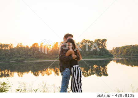 People, love and nature concept - Portrait of young beautiful couple embracing each other while 48958108