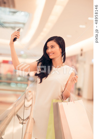 Pretty woman taking selfie in mall 48958146