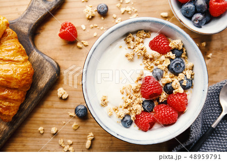 Yogurt with berries and granola in bowl 48959791