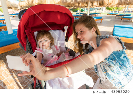 Mother taking selfie with baby on resort 48962020