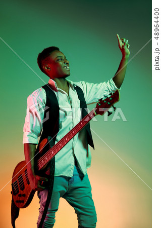 African American handsome jazz musician holding bass guitar and welcomes the audience. 48964400
