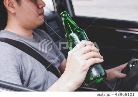 Young asian man drives a car with drunk a bottle 48966101