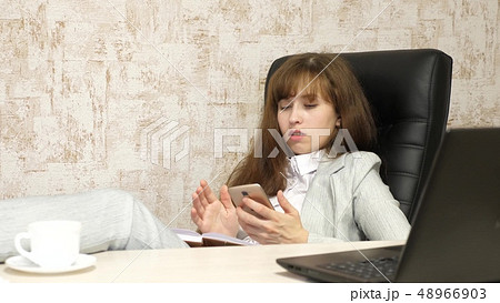 woman in office resting in workplace. beautiful businesswoman with phone sits in a chair with bare 48966903