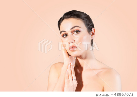 Young woman with clear skin touching her hands her face. 48967073