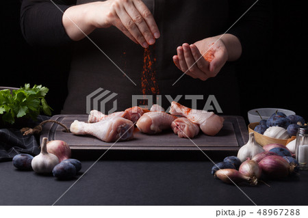 A woman chef prepares a chicken. 48967288