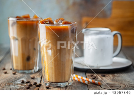 Ice coffee in a tall glass with cream. 48967346