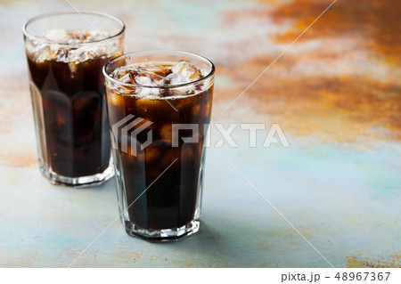 Ice coffee in a tall glass. 48967367