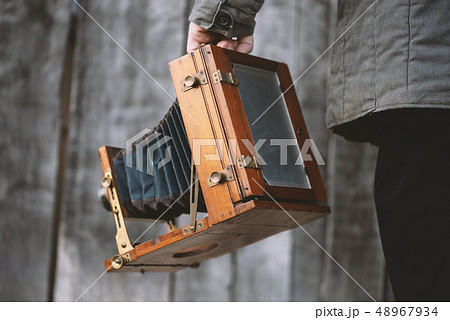 Photographer holds vintage large format studio camera. Concept - photography of the 1930s-1950s 48967934