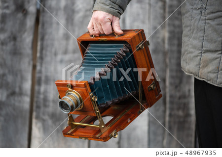 Photographer holds old large format studio camera, 5x7 inches. Concept - photography of the 1930s 48967935