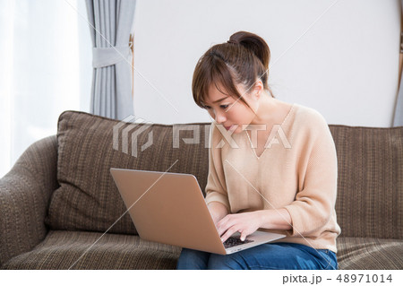 ソファでパソコンを使う女性 48971014