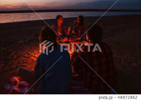 young friends have picnic with bonfire on the beach 48972862