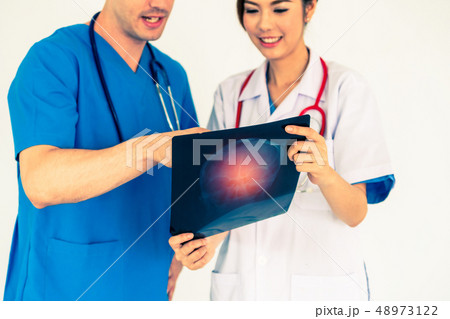 Doctors working with x ray film of patient head. 48973122