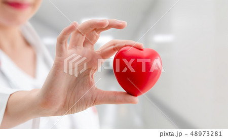 Doctor holding a red heart at hospital office. Doctor holding a red heart at hospital office. 48973281