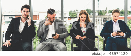 Businesswomen and businessmen using mobile phone. 48974120