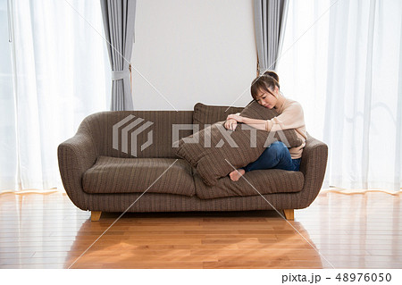 ソファに座って思い悩む女性 ソファに座って思い悩む女性 48976050