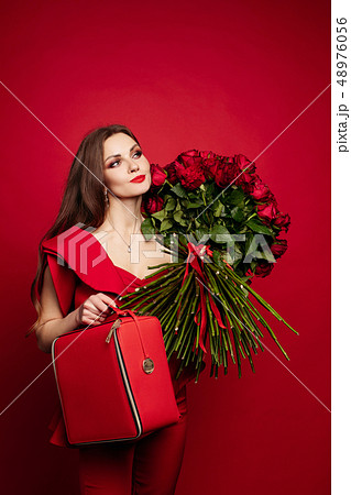 Girl with big bouquet of red roses on shoulder Girl with big bouquet of red roses on shoulder 48976056