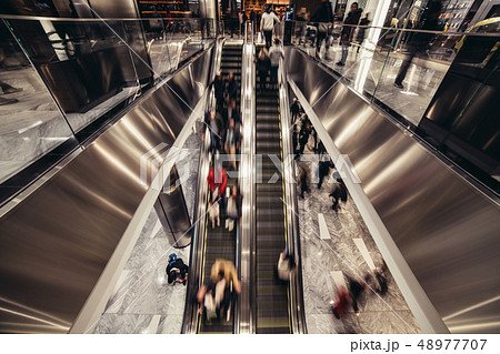 people on an escalator moving in the shopping mall 48977707