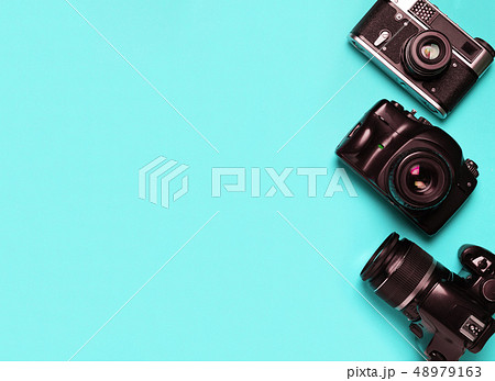 Three vintage old photo camera on a blue 48979163