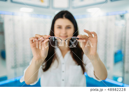 Female customer holds glasses in hand, optic store Female customer holds glasses in hand, optic store 48982228