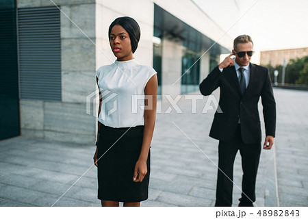 Bodyguard in sunglasses and black business woman Bodyguard in sunglasses and black business woman 48982843