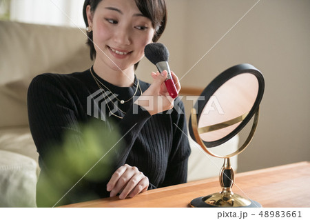 ブラシでチークを塗る若い日本人女性 48983661